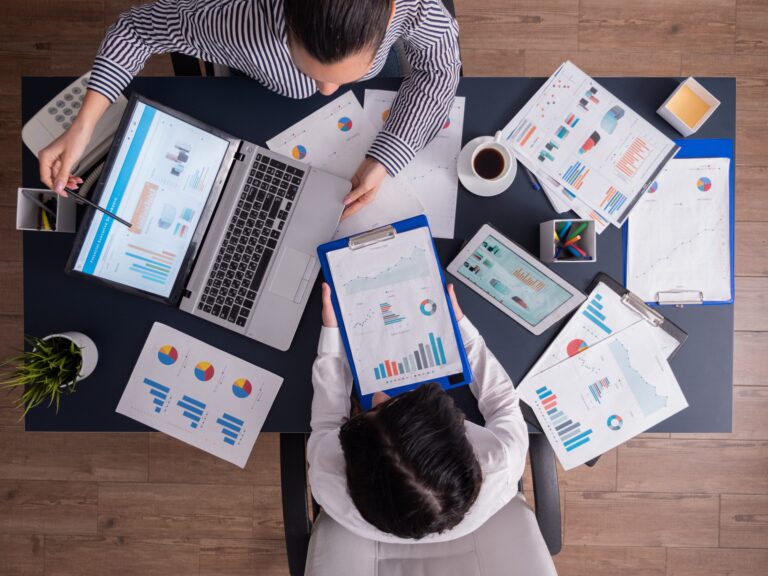 top-viewtop-view-manager-employee-doing-teamwork-business-office-looking-charts-laptop-display-scaled-1